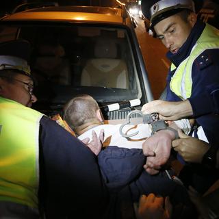 Des policiers de Krasnoïarsk en Sibérie menottent le passager d'un véhicule soupçonné de trafic de drogue. [Reuters - Ilya Naymushin]