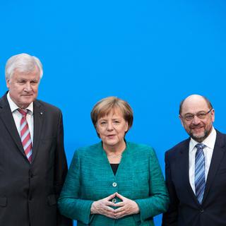 Horst Seehofer (CSU), Angela Merkel (CDU) et Martin Schulz (SPD) devant la presse après l'annonce de la coalition. [Keystone - EPA/Hayong Jeon]