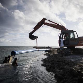 Des ouvriers installent des canalisations provisoires à Boracay, aux Philippines, une île victime du tourisme de masse. [AFP - Noël Celis]