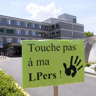 Une pancarte de militants devant l'entrée principale de l'Hôpital fribourgeois, lors d'un rassemblement des employés en grève le 22 mai 2018. [Keystone - Anthony Anex]