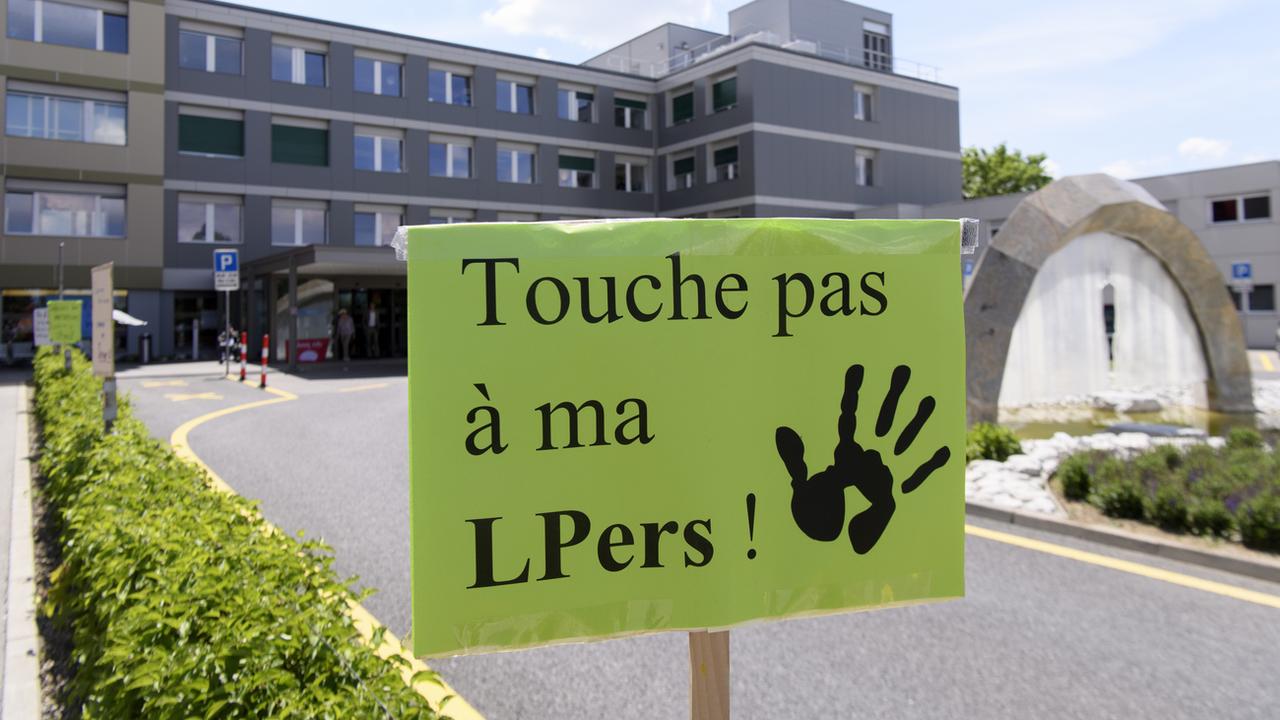 Une pancarte de militants devant l'entrée principale de l'Hôpital fribourgeois, lors d'un rassemblement des employés en grève le 22 mai 2018. [Keystone - Anthony Anex]