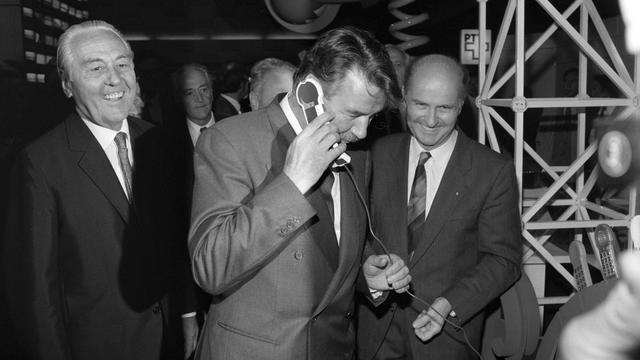 Le conseiller fédéral René Felber, au centre, en visite au stand des PTT du Comptoir Suisse, en septembre 1988. [Keystone]