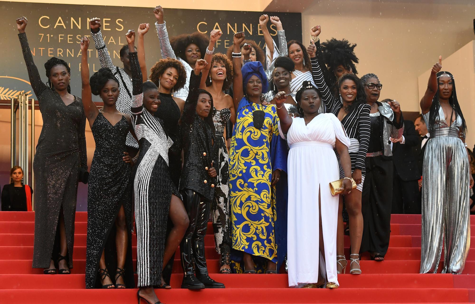 French actress Eye Haidara, French actress Maimouna Gueye, French director Magaajyia Silberfeld, French actress and producer France Zobda and French actress Sabine Pakora, (C fromL) French writer Rachel Khan, French actress and Miss France 2000 Sonia Rolland, French actress Aissa Maiga, French-Portuguese actress Sara Martins, French actress Firmine Richard, (front from L) French actress Assa Sylla, French actress Karidja Toure, French comedian and humorist Shirley Souagnon and French-Cameroonian Marie-Philomene Nga, some of the 16 black women who fight for equality and inclusion of black women in the French film industry pose on May 16, 2018 with Burundian singer and member of the Feature Film Jury Khadja Nin (C) as they arrive for the screening of the film "Burning" at the 71st edition of the Cannes Film Festival in Cannes, southern France. [AFP - Loic Venance]