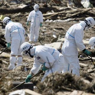 Des travailleurs dans la région de Fukushima, au nord-est du Japon, quelques jours après la catastrophe nucléaire du 11 mars 2011. [keystone - Takuya Yoshino]