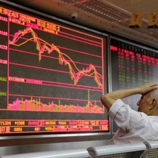 Un petit investisseur regarde la graphique de la bourse dans un bureau de courtage de Pékin. [Reuters - Jason Lee]
