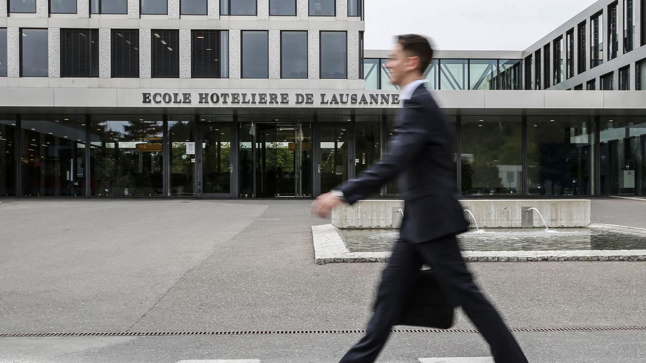 Un étudiant passe devant l'entrée de l'Ecole Hôtelière de Lausanne (EHL). [Keystone - Peter Klaunzer]