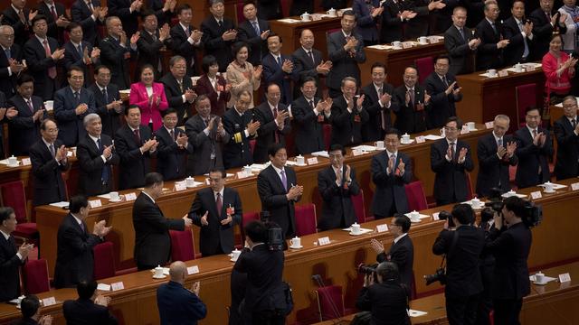 Les députés chinois applaudissent Xi Jinping après sa réélection à la tête du pays. [AP Photo/Keystone - Andy Wong]