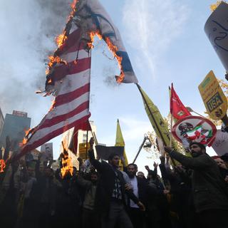 Des manifestants iraniens brûlent la bannière des Etats-Unis devant l'ambassade américaine à Téhéran. [AFP - Atta Kenare]