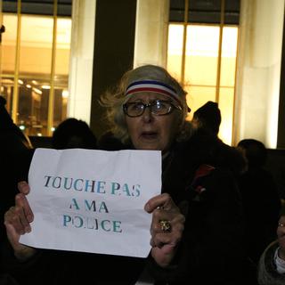 Une femme manifeste en soutien à la police française à Paris le 2 janvier. [CrowdSpark/AFP - Anthony Deperraz]