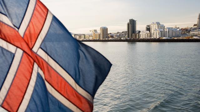 Un drapeau islandais flotte avec Reykjavik, la capitale du pays, en arrière-plan. [AFP - Stuart Westmorland]