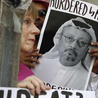 Une photo de Jamal Khashoggi brandie lors d'une manifestation à Washington cette semaine. [Keystone - AP Photo/Jacquelyn Martin]