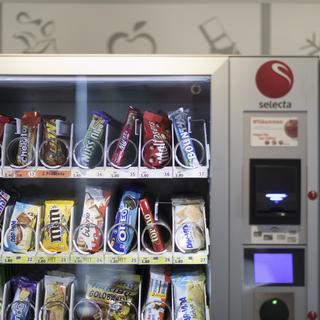 Les députés fribourgeois ont accepté d'interdire ou de limiter les automates proposant de barres chocolatées et des sodas dans les écoles. [Gaetan Bally - Keystone]
