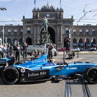Sébastien Buemi et sa Formule E devant la gare centrale de Zurich lors d'un événement de promotion du Grand Prix de dimanche, en avril dernier. [Keystone - Ennio Leanza]