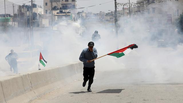 Des Palestiniens manifestent près du checkpoint de Ramallah, en Cisjordanie, lundi 14 mai, jour de l'inauguration de l'ambassade américaine à Jérusalem. [keystone - ALAA BADARNEH]