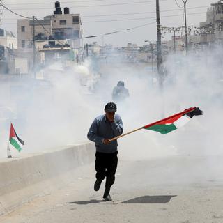 Des Palestiniens manifestent près du checkpoint de Ramallah, en Cisjordanie, lundi 14 mai, jour de l'inauguration de l'ambassade américaine à Jérusalem. [keystone - ALAA BADARNEH]