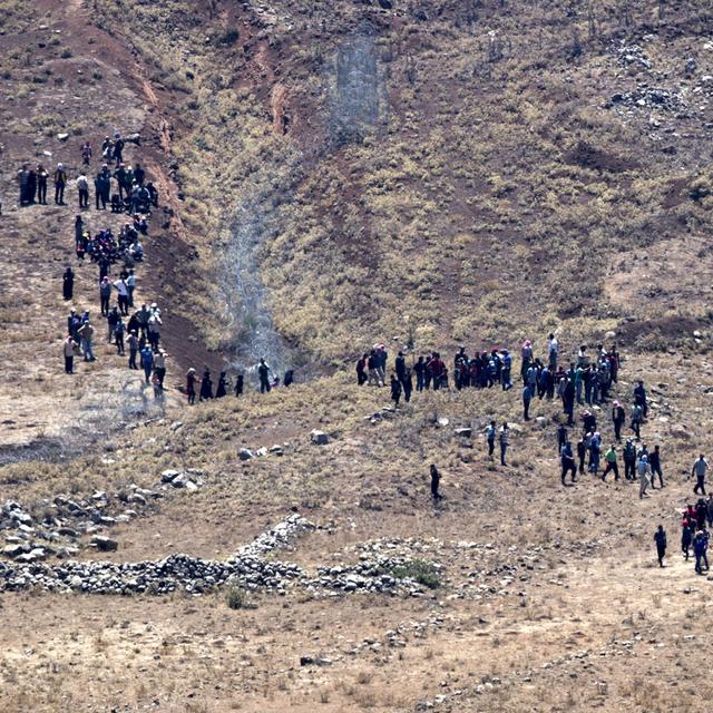 Des réfugiés syriens marchent dans le Golan en direction de la frontière israélienne. [EPA - Atef Safadi]