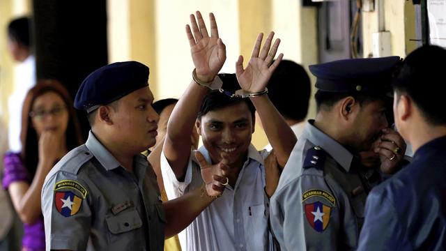 Kyaw Soe Oo (centre) montre ses menottes aux photographes à son arrivée au tribunal, ce lundi 3 septembre 2018 à Rangoun.