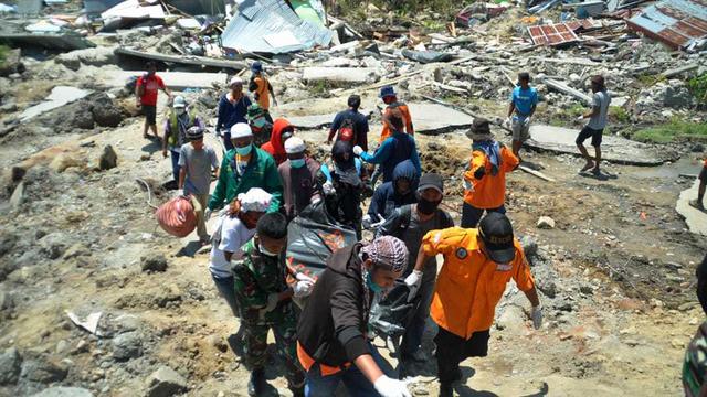 Des équipes de secouristes évacuent les corps des victimes du séisme à Palu, en Indonésie. [AP Photo - Rifki]