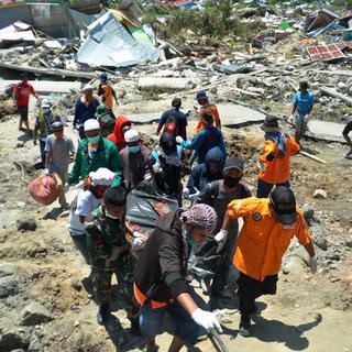 Des équipes de secouristes évacuent les corps des victimes du séisme à Palu, en Indonésie. [AP Photo - Rifki]