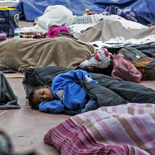 Un enfant de la "caravane des migrants" dort à Tijuana, au Mexique, près de la frontière avec les Etats-Unis. [AFP - Guillermo Arias]