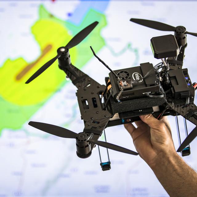 Un drone au-dessus d'une carte montrant les zones interdites autour de l'aéroport de Genève. [Keystone - Valentin Flauraud]