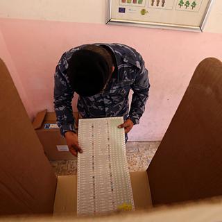 Un officier de police irakien prépare son bulletin de vote. [Keystone - Hadi Mizban]