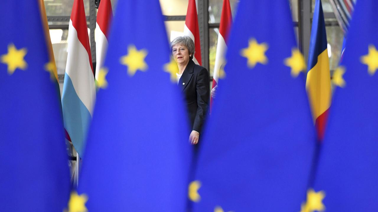 Brexit: la Première ministre britannique Theresa May cachée derrière le drapeau européen. [Keystone - AP Photo/Geert Vanden Wijngaert]