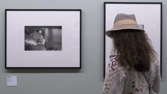 Une visiteuse admire l'une des photographies de Robert Frank exposées à Arles. [afp - Bertrand Langlois]