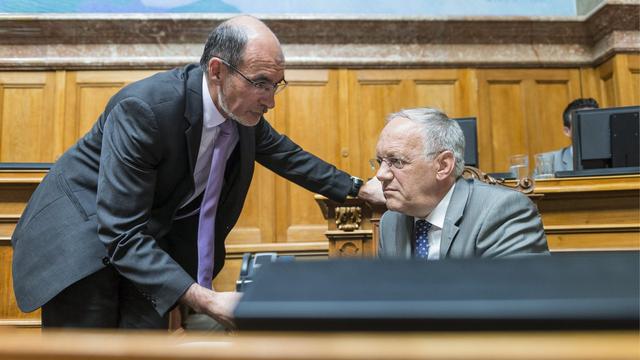 Jacques Bourgeois (USP) en discussion avec Johann Schneider-Ammann au National en 2013. [Keystone - Alessandro della Valle]