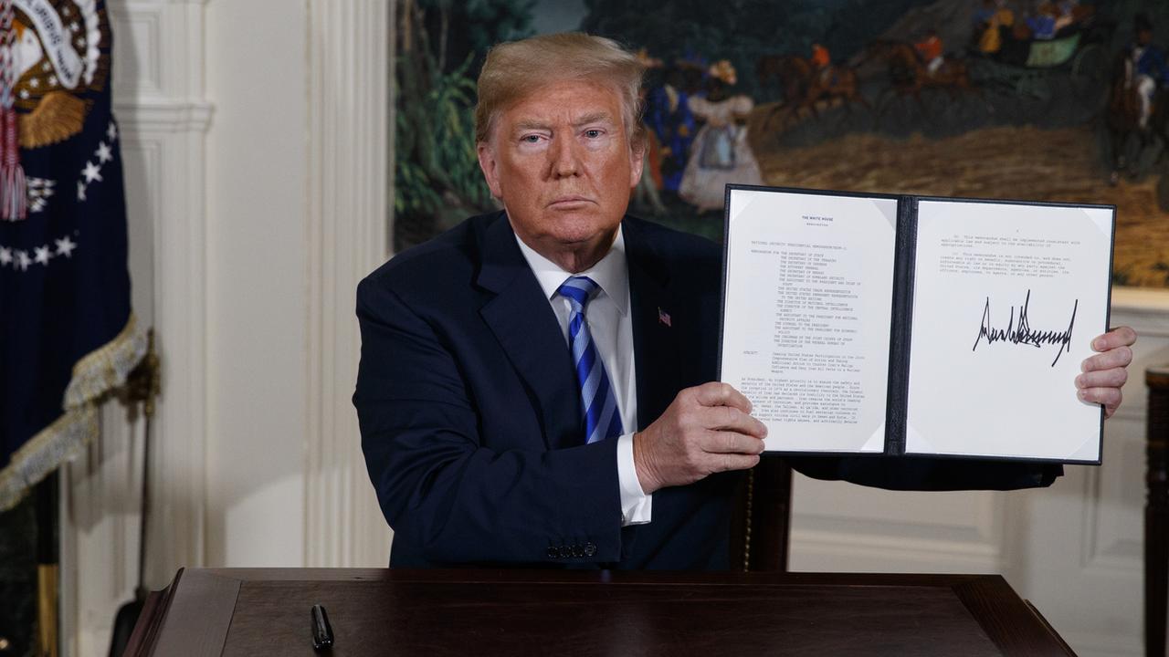 Le président américain Donald Trump montre la signature du document rétablissant les sanctions contre Téhéran. [Keystone - Evan Vucci]
