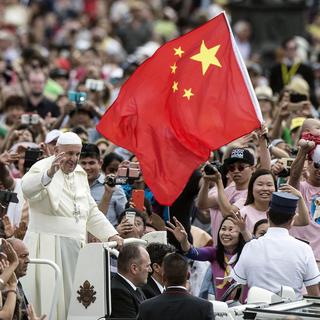 Des Chinois agitent le drapeau national pour accueillir le pape François sur la place St-Pierre au Vatican. [EPA / Keystone - Angelo Carconi]