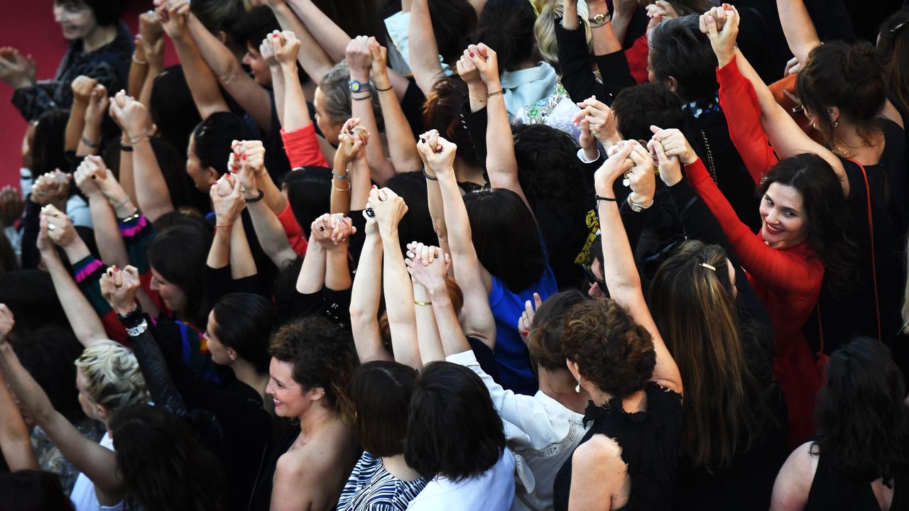 Des réalisatrices, des comédiennes et productrices se tiennent la main sur le tapis rouge de Cannes pour protester contre le peu de femmes primées sur la Croisette. [AFP - Anne-Christine Poujoulat]