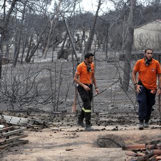 Des secouristes cherchent des personnes disparues dans un quartier de la ville grecque de Mati, ravagée par les flammes. [EPA - Simela Pantzartz]
