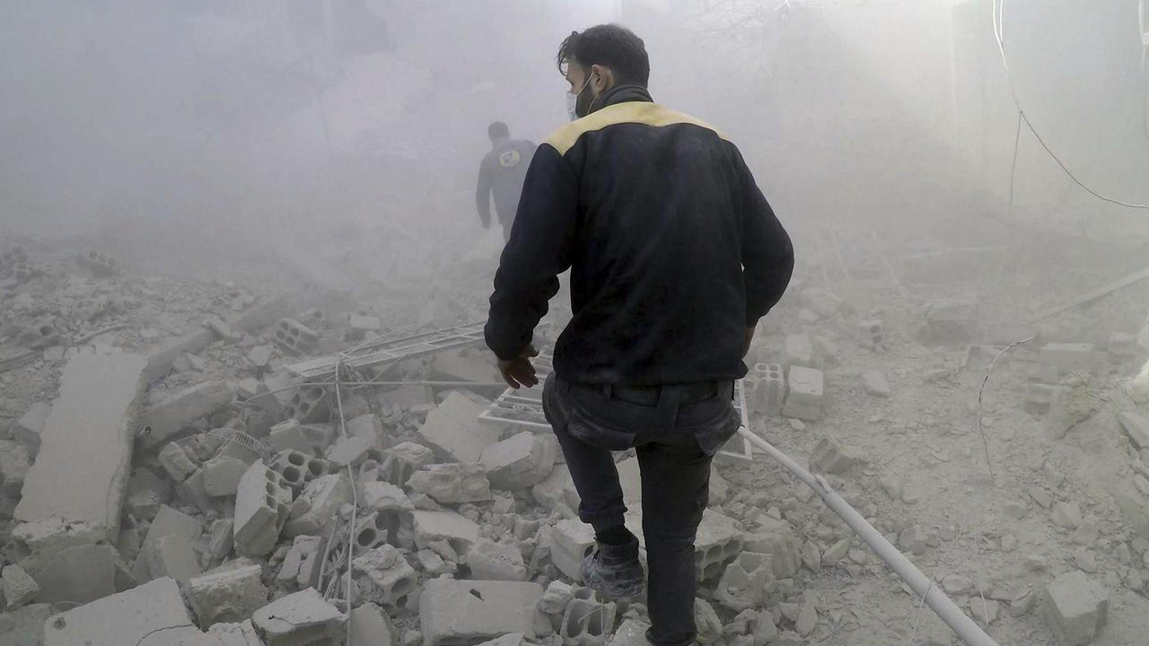 Les Casques blancs à la recherche de survivants après des raids aériens en Syrie, dans la Ghouta orientale. [Helmets/AP/Keystone - Défense civile syrienne]