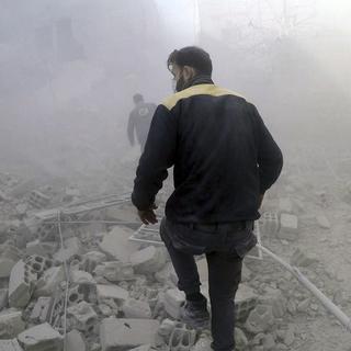 Les Casques blancs à la recherche de survivants après des raids aériens en Syrie, dans la Ghouta orientale. [Helmets/AP/Keystone - Défense civile syrienne]