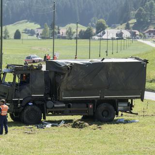 Le camion de l'armée s'est renversé dans un champ à Linden (BE). [Keystone - Peter Schneider]