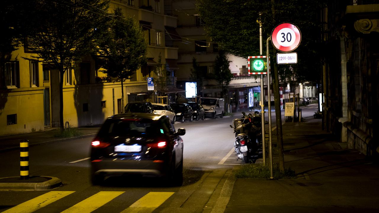 Une voiture roule de nuit à Lausanne. [Keystone - Jean-Christophe Bott]