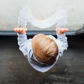 Un enfant regarde à travers une vitre. [Image envoyée par e-mail - Paul Hanaoka]