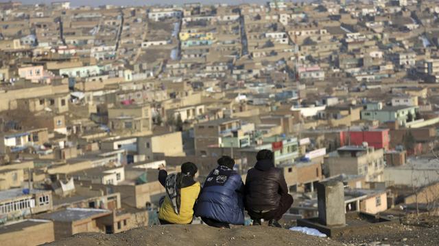 Mardi 30 janvier: trois enfants contemplent un quartier populaire de Kaboul, en Afghanistan. [Keystone - AP Photo/Rahmat Gul]