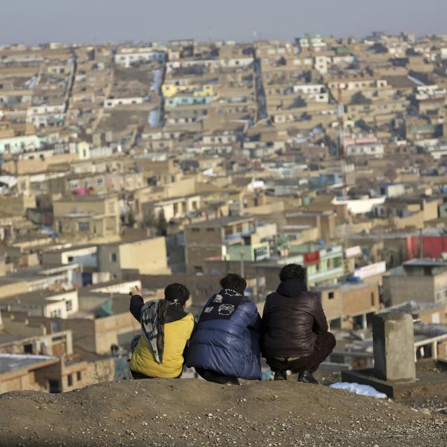 Mardi 30 janvier: trois enfants contemplent un quartier populaire de Kaboul, en Afghanistan. [Keystone - AP Photo/Rahmat Gul]