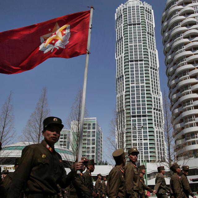 Soldats nord-coréens portant le drapeau de l'Armée populaire, dans un quartier résidentiel de Pyongyang. [Keystone - Wong Maye-E]