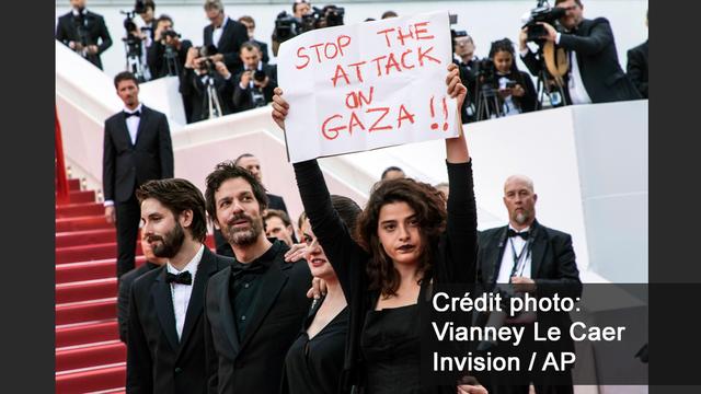 L'actrice Manal Issa a brandi cette affiche de soutien aux Palestiniens lors de la montée des marches. [Invision/AP - Vianney Le Caer]