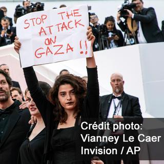L'actrice Manal Issa a brandi cette affiche de soutien aux Palestiniens lors de la montée des marches. [Invision/AP - Vianney Le Caer]