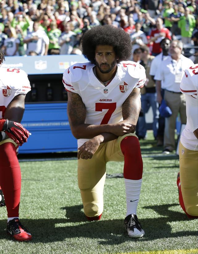 Colin Kaepernick met un genou à terre en signe de protestation contre les violences policières, comme ici, le 25 septembre 2016. [Keystone - Ted S. Warren]