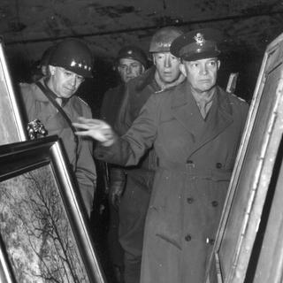Le général Eisenhower examine le 12 avril 1945 des oeuvres d'art volées par le gouvernement nazi dans les pays occupés et cachés dans une mine de sel en Allemagne. [Keystone]