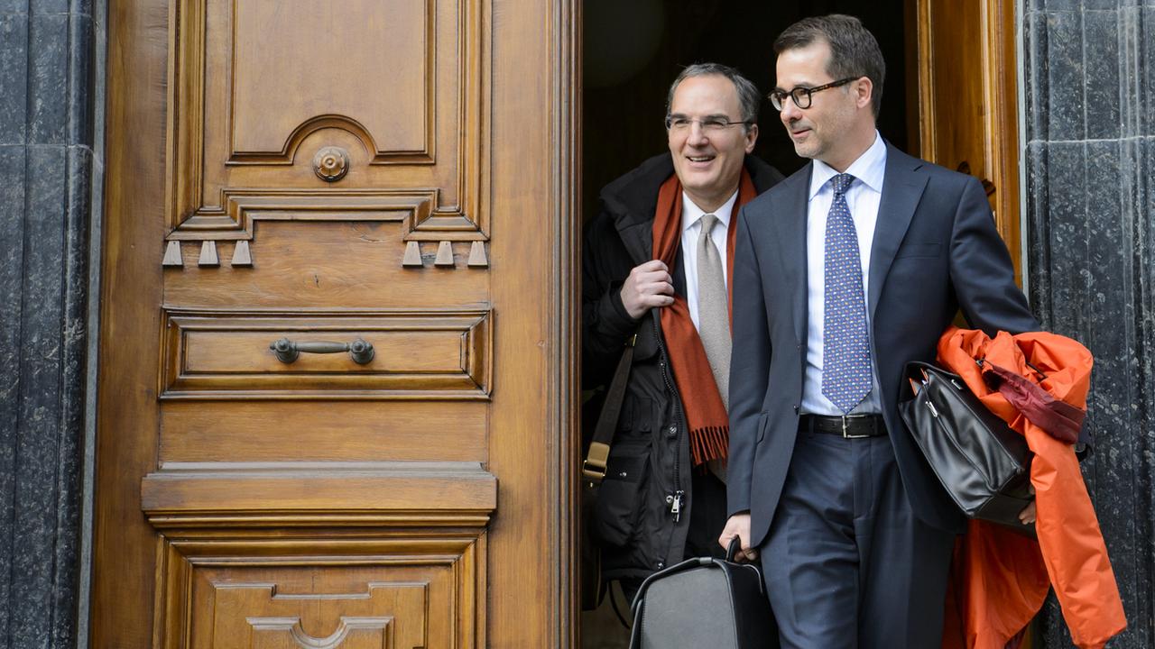 Les avocats de Dominique Giroud, Xavier Oberson (à gauche) et Jacques Pittet (à droite), sortant du tribunal de Sion le 18.02.18. Ils doivent représenter leur client en son absence. [Keystone - Jean-Christophe Bott]