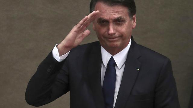 Le président brésilien Jair Bolsonaro salue lors d'une cérémonie officielle à Brasilia en décembre. [Keystone/AP Photo - Eraldo Peres]