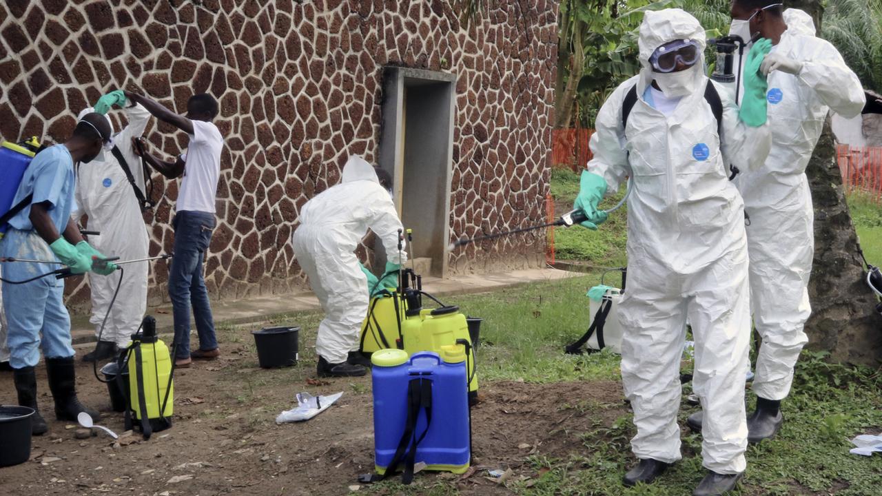 Des collaborateurs des autorités sanitaires de la RDC désinfectent des personnes et des bâtiments (image d'archives). [AP/Keystone - John Bompengo]