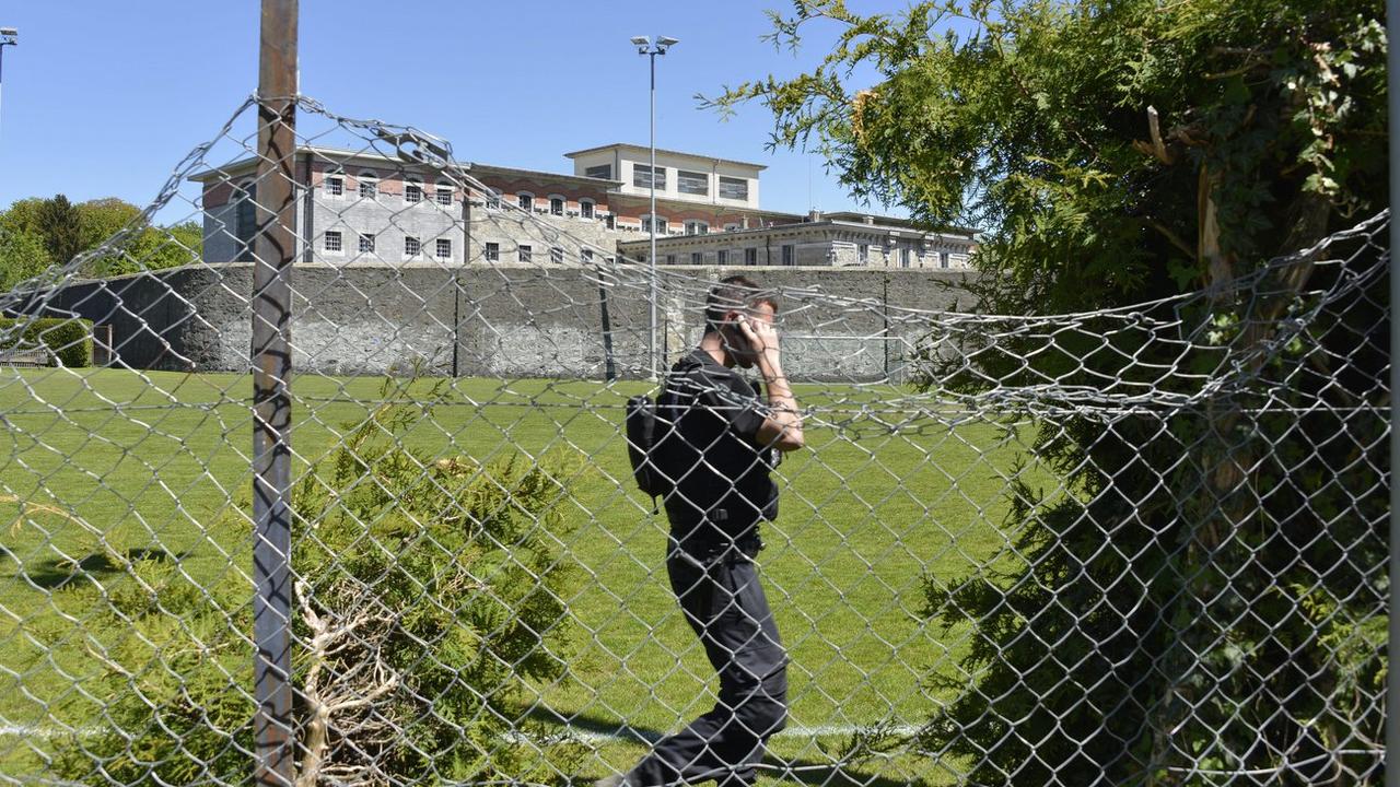 Un policier devant la prison lausannoise de Bois-Mermet, où a eu lieu une évasion en mai 2013. [Keystone - Christian Brun]