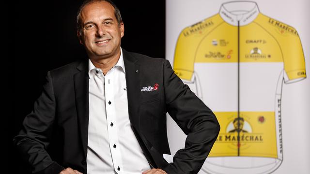 Richard Chassot, directeur du Tour de Romandie, devant le nouveau maillot sponsorisé par Le Maréchal. [Keystone - Valentin Flauraud]